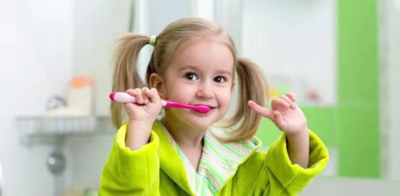 Kleines Mädchen putzt die Zähne mit einer Zahnbürste.